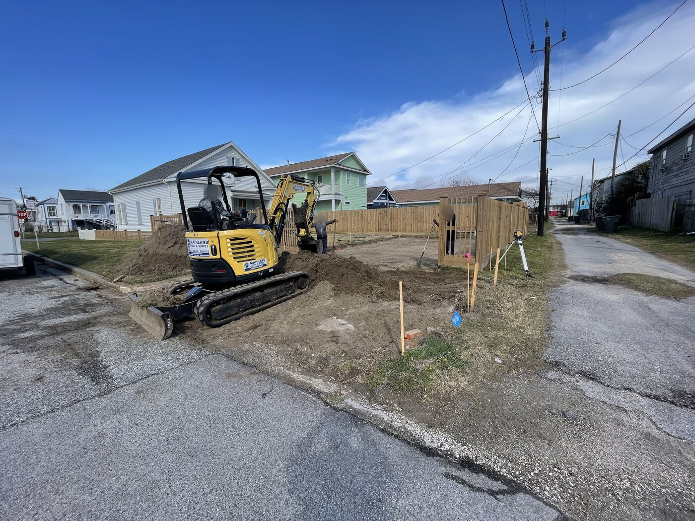 Compact excavator performing site and groundwork on a Galveston property